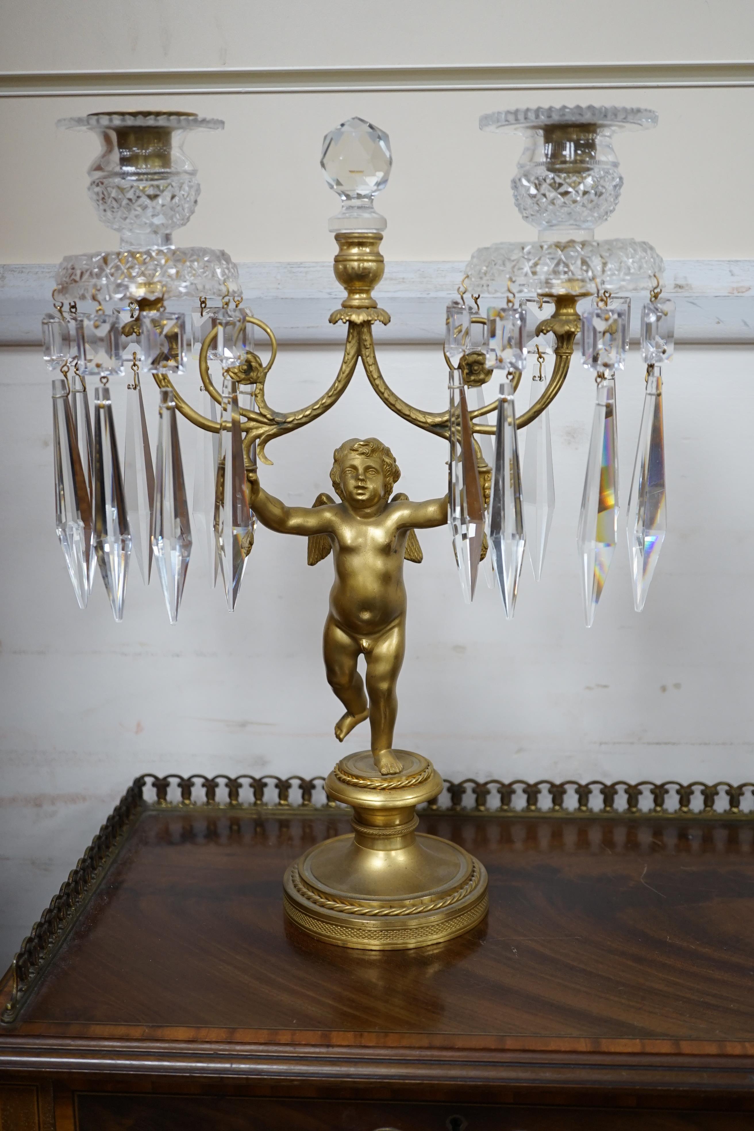 A pair of Regency ormolu ‘Cupid’ two branch glass lustre candelabra, 37cm high